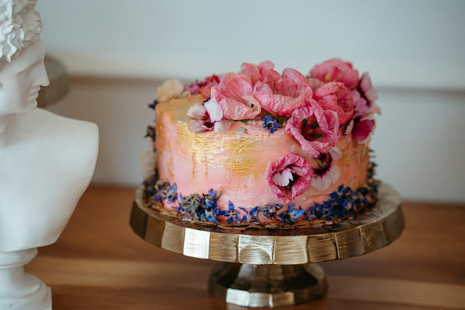 Floral wedding cake styled on a gold stand