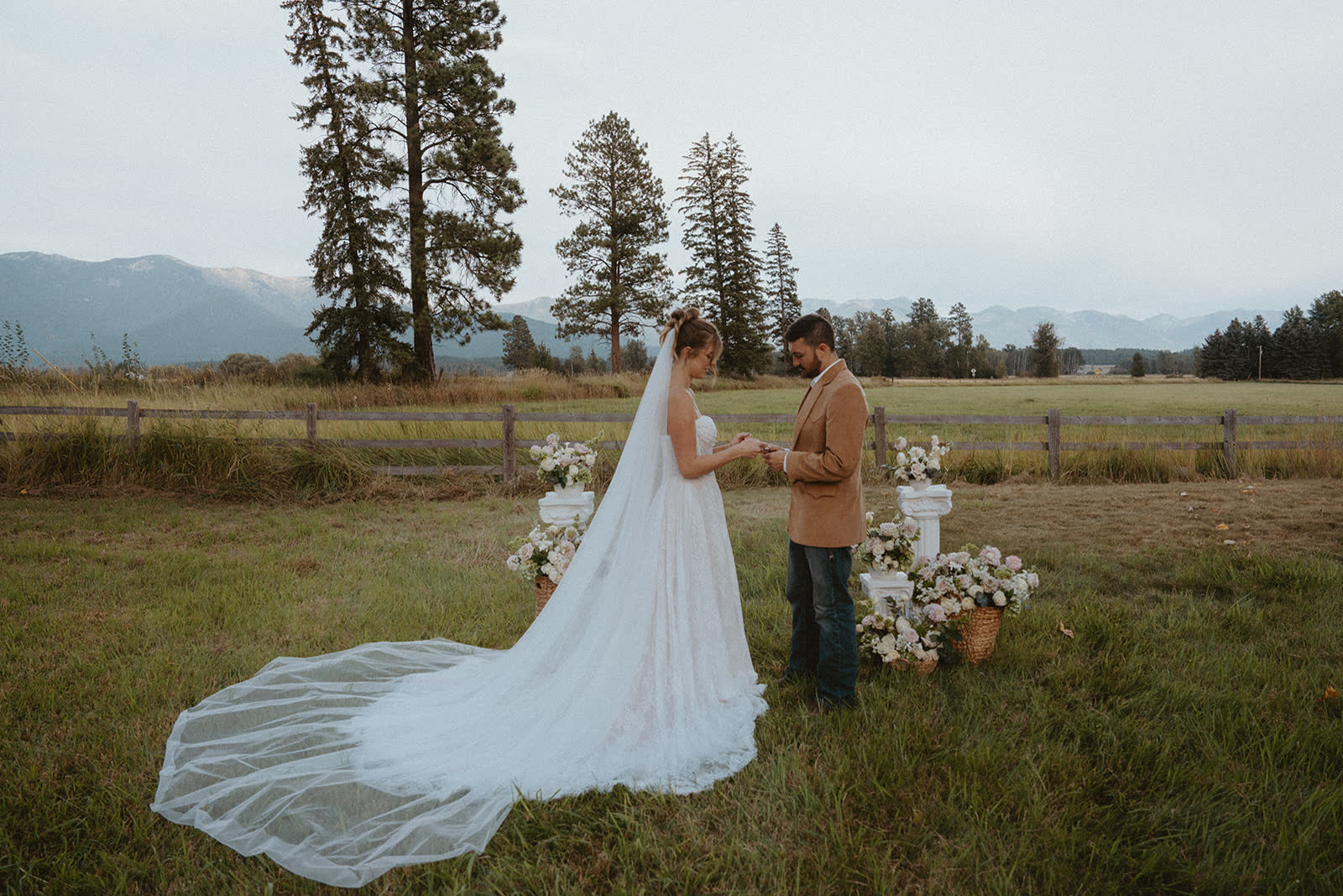 Bride in a Montana meadow, veil drifting in the wind
